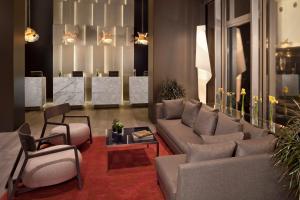 a living room with a couch and chairs and a table at Meliá Barcelona Sky 4 Sup in Barcelona