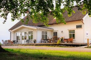 a white building with tables and chairs in front of it at Hensbacka Hotell in Munkedal