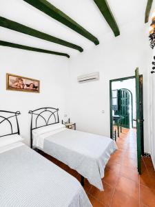 two beds in a room with white walls at Villas El Cañuelo in Monturque +10 photos