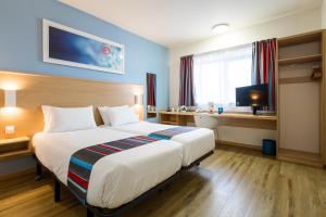 a hotel room with a large bed and a desk at Travelodge Barcelona Fira in Hospitalet de Llobregat +18 photos