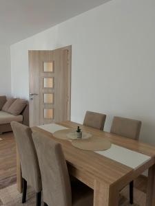 a dining room with a wooden table and chairs at Apartman Šarenac in Bileća