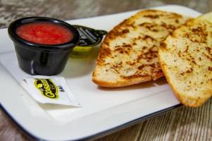 Ein weißer Teller mit einem Sandwich und einer Tasse Soße in der Unterkunft Hotel Complutense in Alcalá de Henares