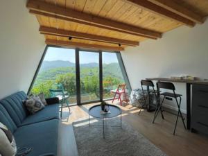 a living room with a blue couch and a large window at Engadin Mountain Kucica in Brda