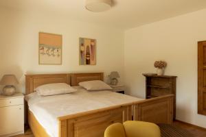 a bedroom with a bed and a chair in it at Macskalépcsős Boutique B&B in Dörgicse