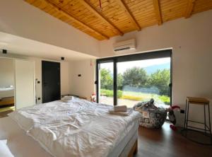 a bedroom with a large bed and a large window at Engadin Mountain Kucica in Brda