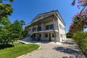 an exterior view of a white building with trees at Residence Da Marco in Pieve di Soligo