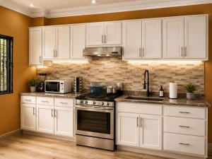 a kitchen with white cabinets and a stove top oven at The Blue Resort in Yaoundé