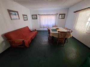 a living room with a couch and a table and chairs at Verbe Farm Accommodation in Kamieskroon
