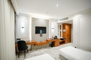 a hotel room with a desk and a tv on the wall at Meridian Plaza by Reikartz in Samarkand