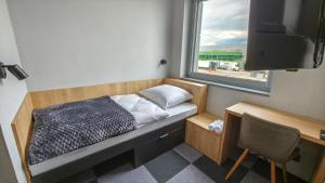 a small bed in a room with a window at Rest&Drive in Warszowice