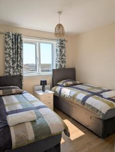 a bedroom with two beds and a window at Mach House in Campbeltown