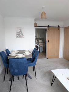 a dining room with a table and blue chairs at Mach House in Campbeltown