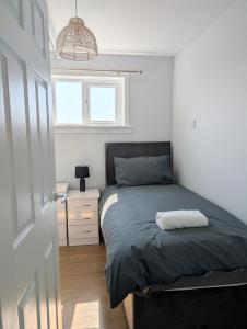a small bedroom with a bed and a night stand at Mach House in Campbeltown