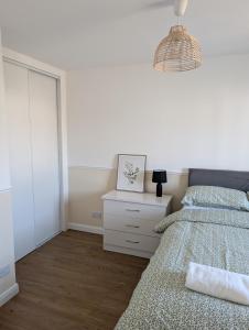 a bedroom with a bed and a dresser and a mirror at Mach House in Campbeltown +2 photos