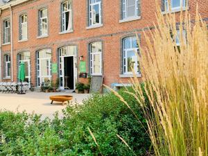 a brick building with a bench in front of it at De Lotuspoort met Mihr's rustplek in de Abdij van Bornem in Bornem
