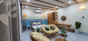 a living room with chairs and a bed and a table at Bee House in Long Thủy