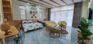 a living room with a bed and chairs in a room at Bee House in Long Thủy