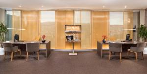 a conference room with two tables and chairs and windows at The Level at Meliá Barcelona Sky in Barcelona