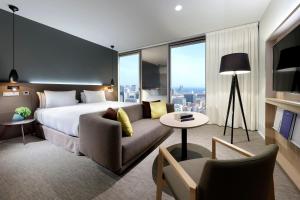 a hotel room with a bed and a couch at The Level at Meliá Barcelona Sky in Barcelona