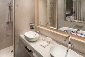 a bathroom with two sinks and a mirror and a tub at The Level at Meliá Barcelona Sky in Barcelona