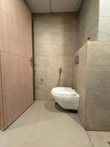 a bathroom with a white toilet and a door at The Skyline Studio in Greater Noida