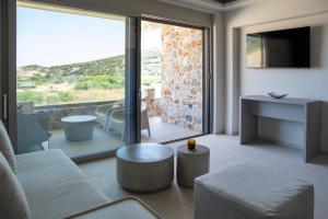 a living room with a couch and a tv at Stone Luxury Suites in Agioi Apostoli