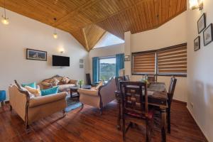 a living room with a table and chairs at Villa Harrington in Barog