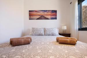 a bedroom with a bed with two ottomans at Casa Yoaki in Corralejo