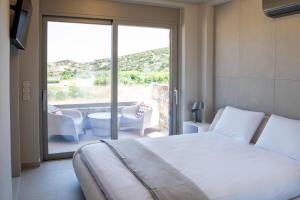 a bedroom with a bed and a balcony with a tub at Stone Luxury Suites in Agioi Apostoli +60 photos