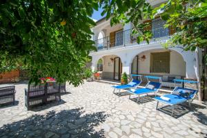 a patio with blue chairs and a building at Il Vigneto in Tramonti