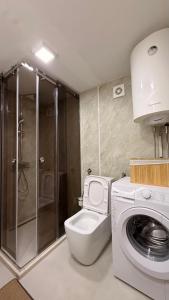 a bathroom with a toilet and a washing machine at Mountain Paradise House in Žabljak +21 photos