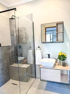 a bathroom with a glass shower and a sink at Die Boord Guesthouse in Crocodile Valley Estates +26 photos