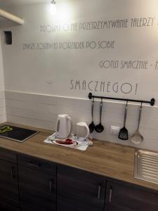 a kitchen counter with two cups and utensils on it at U Jaśka in Darłowo