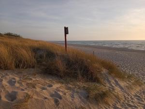 a sign on a beach next to the ocean at U Jaśka in Darłowo