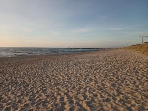 a sandy beach with the ocean in the background at U Jaśka in Darłowo