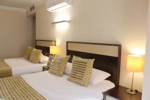 a hotel room with two beds and two lamps at Akkoç Butik Otel in Seyhan