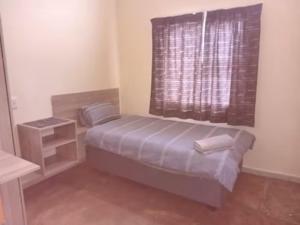a small bedroom with a bed and a window at Red Rocks Accommodation in Northam