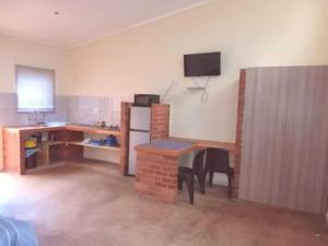 a room with a kitchen with a table and a refrigerator at Red Rocks Accommodation in Northam