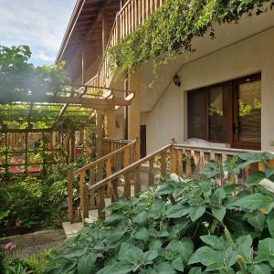 a house with a wooden staircase and plants at Guest House Nash Dom in Kavarna