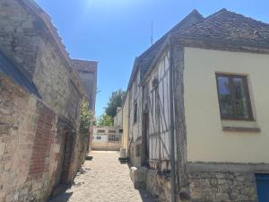 an alley in an old stone building with a window at Le loft sous les colombages in Gouffern en Auge