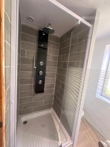 a shower with a glass door in a bathroom at Le loft sous les colombages in Gouffern en Auge