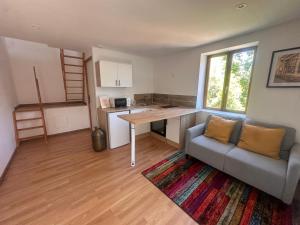 a living room with a couch and a table at Le loft sous les colombages in Gouffern en Auge
