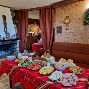 a table with plates of food on a red table cloth at Guest House Nash Dom in Kavarna