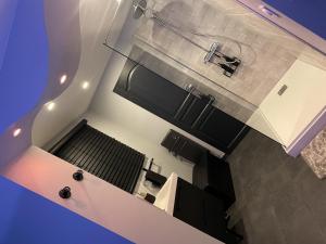 an overhead view of a kitchen with black and white appliances at Love Room SPA l'impertinente in Isbergues +51 photos