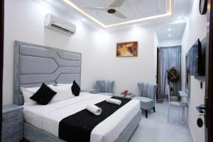 a hotel room with a bed and a table and chairs at Hotel Haven Lahore in Lahore