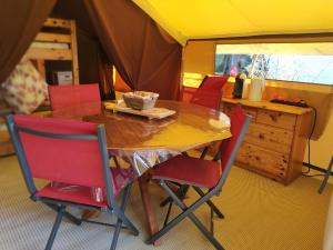 a dining room with a table and red chairs at clos du loguy in Pénestin