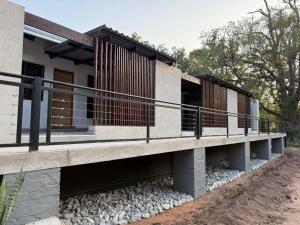 a modern house with a deck on the side of it at Die Boord Guesthouse in Crocodile Valley Estates