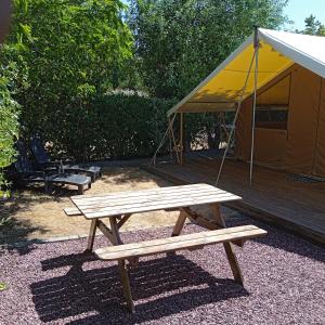 a picnic table and a tent in a yard at clos du loguy in Pénestin +4 photos