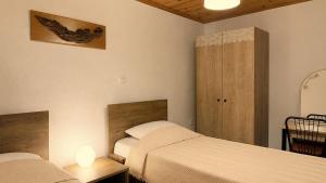 a bedroom with two beds and two lamps and a door at Meliti Home in Therma +7 photos
