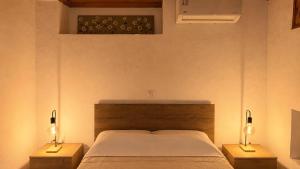 a bedroom with a bed and two night stands with lamps at Meliti Home in Therma